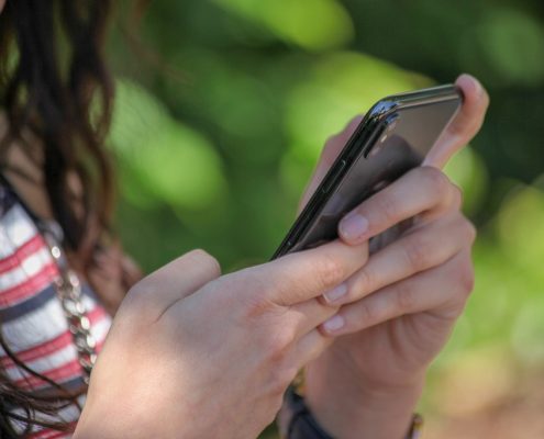 Eine junge Frau hält ein Smartphone