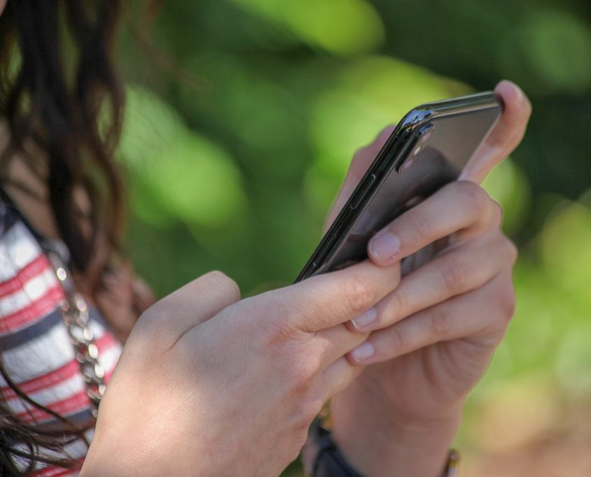 Eine junge Frau hält ein Smartphone